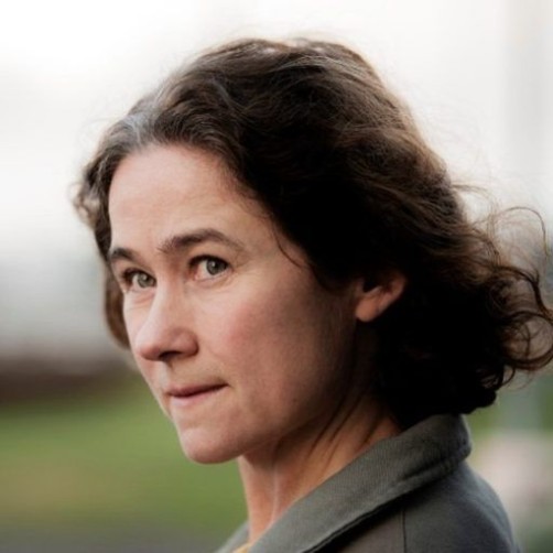 Närbild på en kvinna som tittar snett in i bild med vind i håret