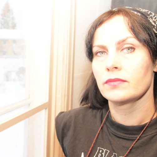 En blek bild av en kvinna vid ett fönster